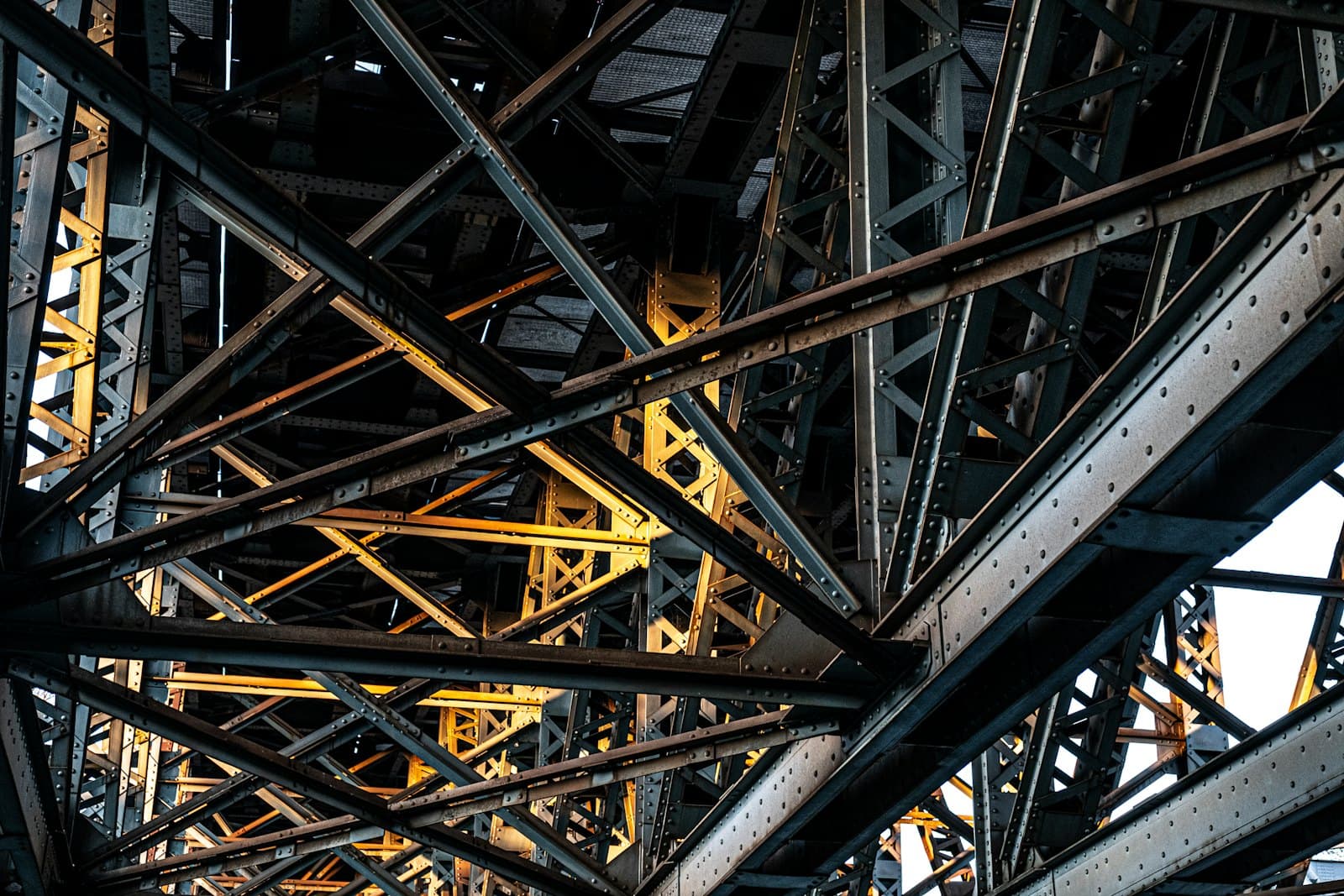 Crisscrossing riveted steel beams lit in golden light — illustrative image for the demo